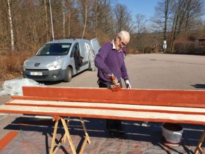 Kent-Arne målar plankor till staket för Tjäderstigen